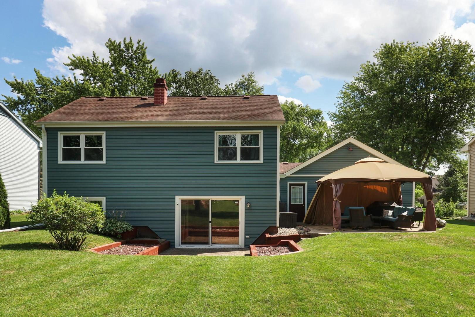 1016 Butler Drive Crystal Lake, IL 60014 - Photo 19 of 20 a front view of a house with a garden and trees