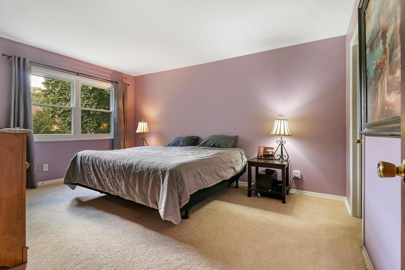 1016 Butler Drive Crystal Lake, IL 60014 - Photo 9 of 20 a spacious bedroom with a bed lamp and window