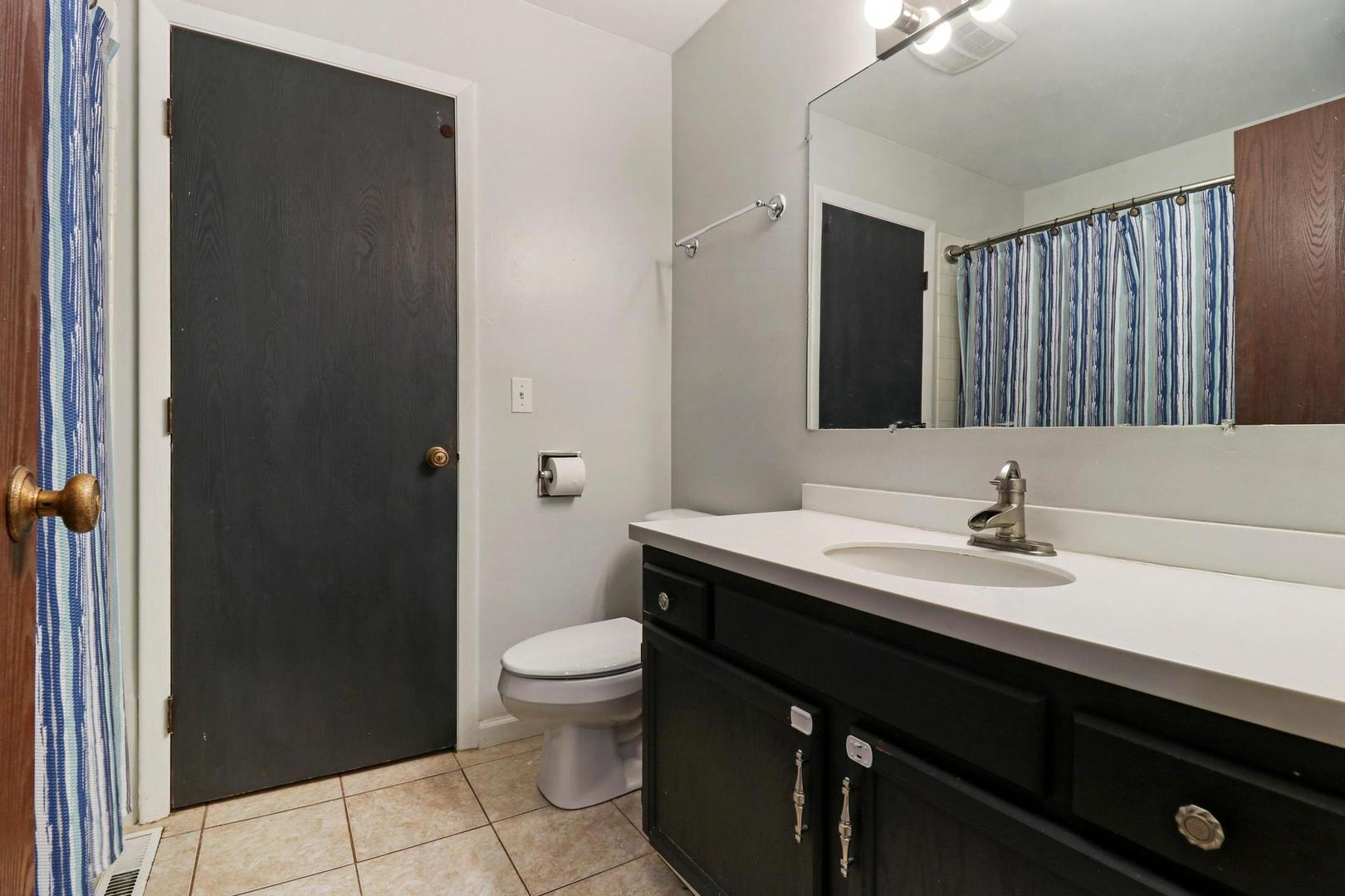 1016 Butler Drive Crystal Lake, IL 60014 - Photo 10 of 20 a bathroom with a granite countertop sink toilet a mirror and shower