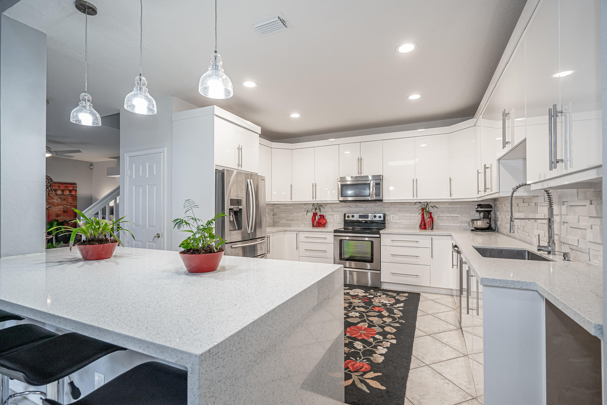 22821 Chelsea Wood Court Boca Raton, FL 33433 - Photo 10 of 43 a kitchen with stainless steel appliances kitchen island granite countertop a sink and cabinets