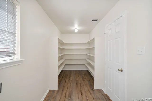 a view of a hallway with wooden floor and entryway