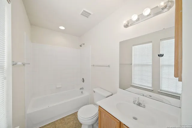 a bathroom with a sink toilet vanity and shower