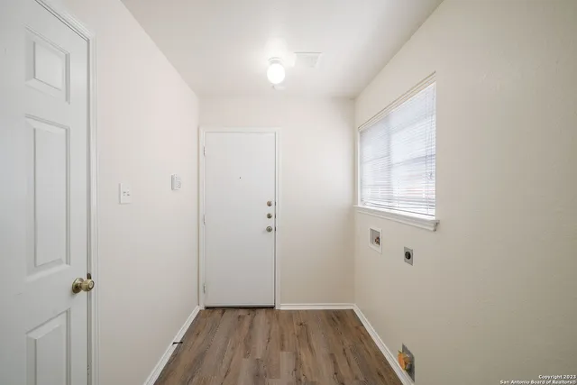 a view of a room with wooden floor and a window