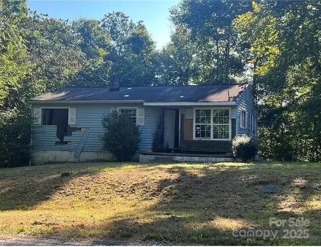 a view of a house with a yard chairs and wooden fence