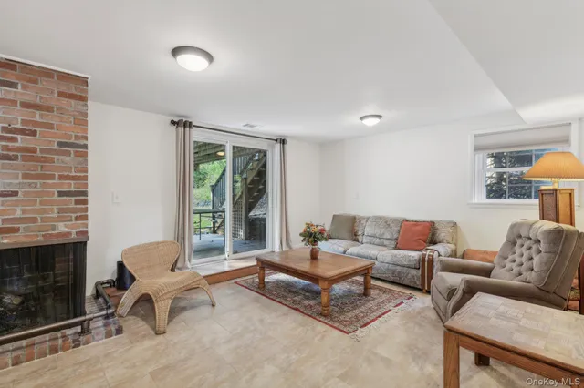 a living room with furniture a fireplace and a floor to ceiling window