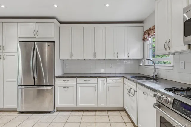 a kitchen with white cabinets and stainless steel appliances