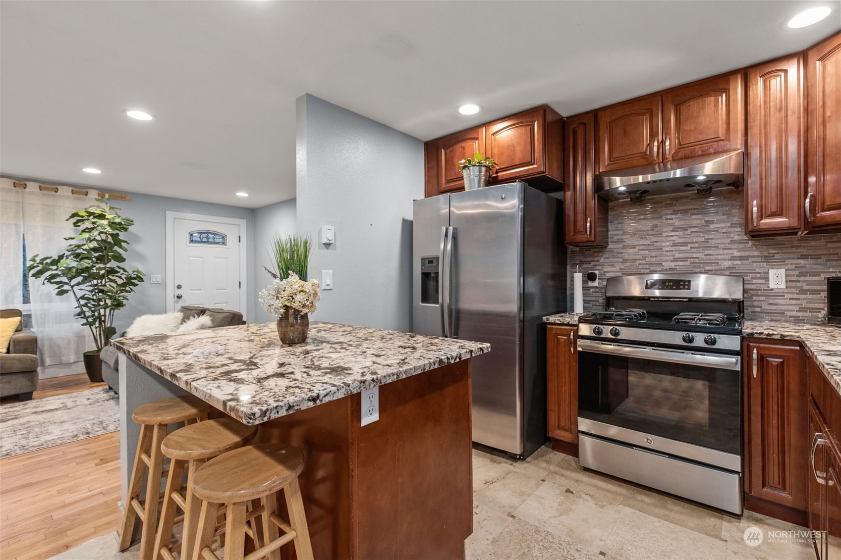 15608 Southeast 128th Street Renton, WA 98059 - Photo 8 of 40 a kitchen with stainless steel appliances kitchen island granite countertop a table chairs stove and refrigerator