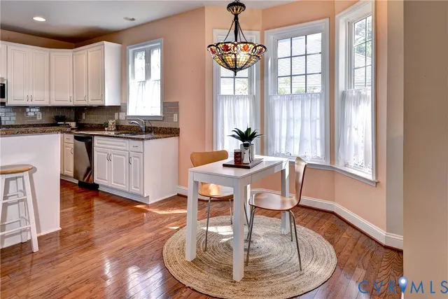 a view of a dining room with furniture a chandelier and wooden floor