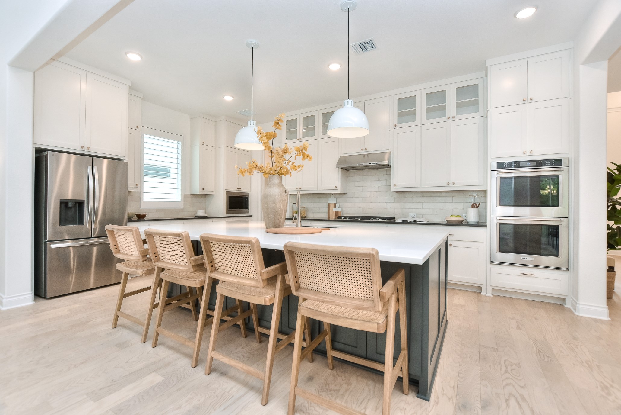 309 Wolf Rdg Road Georgetown, TX 78628 - Photo 9 of 39 Kitchen with stainless steel appliances, decorative light fixtures, light wood-type flooring, an island with sink, and a kitchen bar