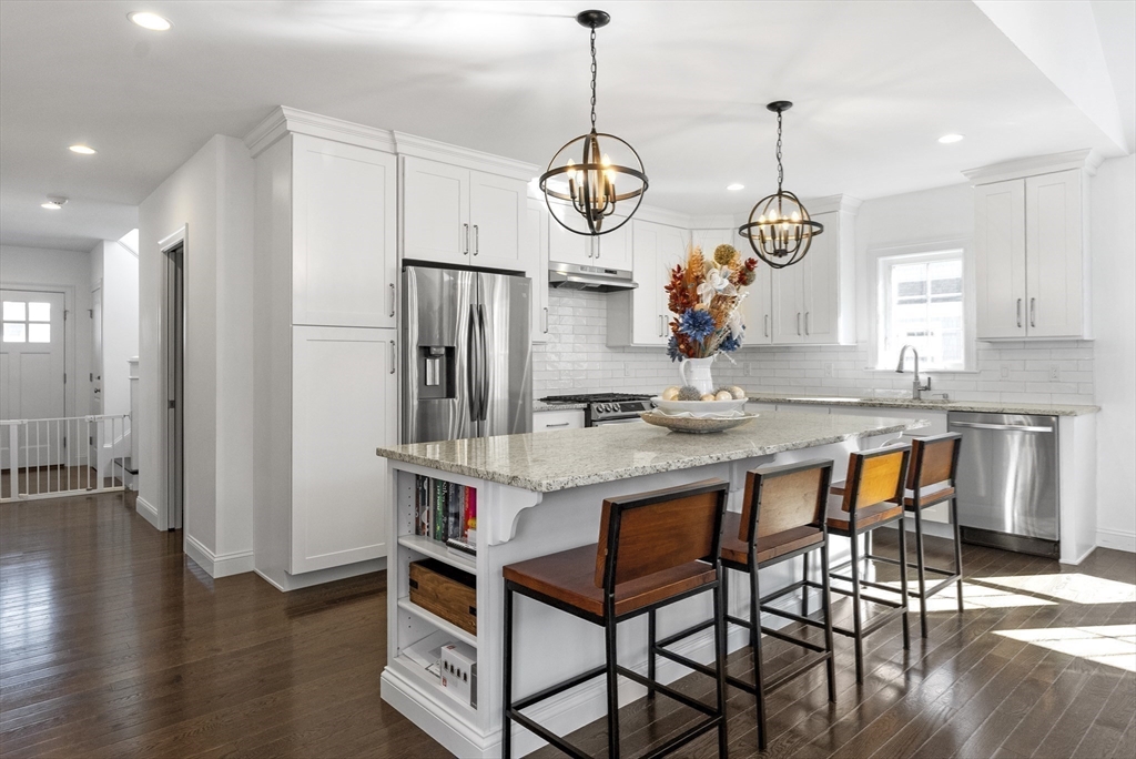 a very nice looking dining room with hardwood floor and a chandelier