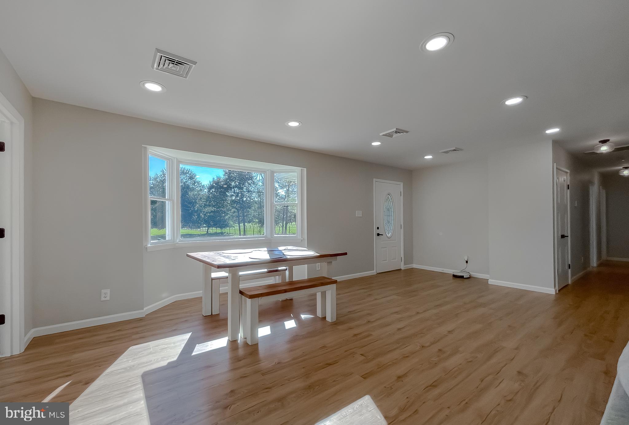 26005 Jones Wharf Road Hollywood, MD 20636 - Photo 13 of 66 a view of a big room with wooden floor and a floor to ceiling window