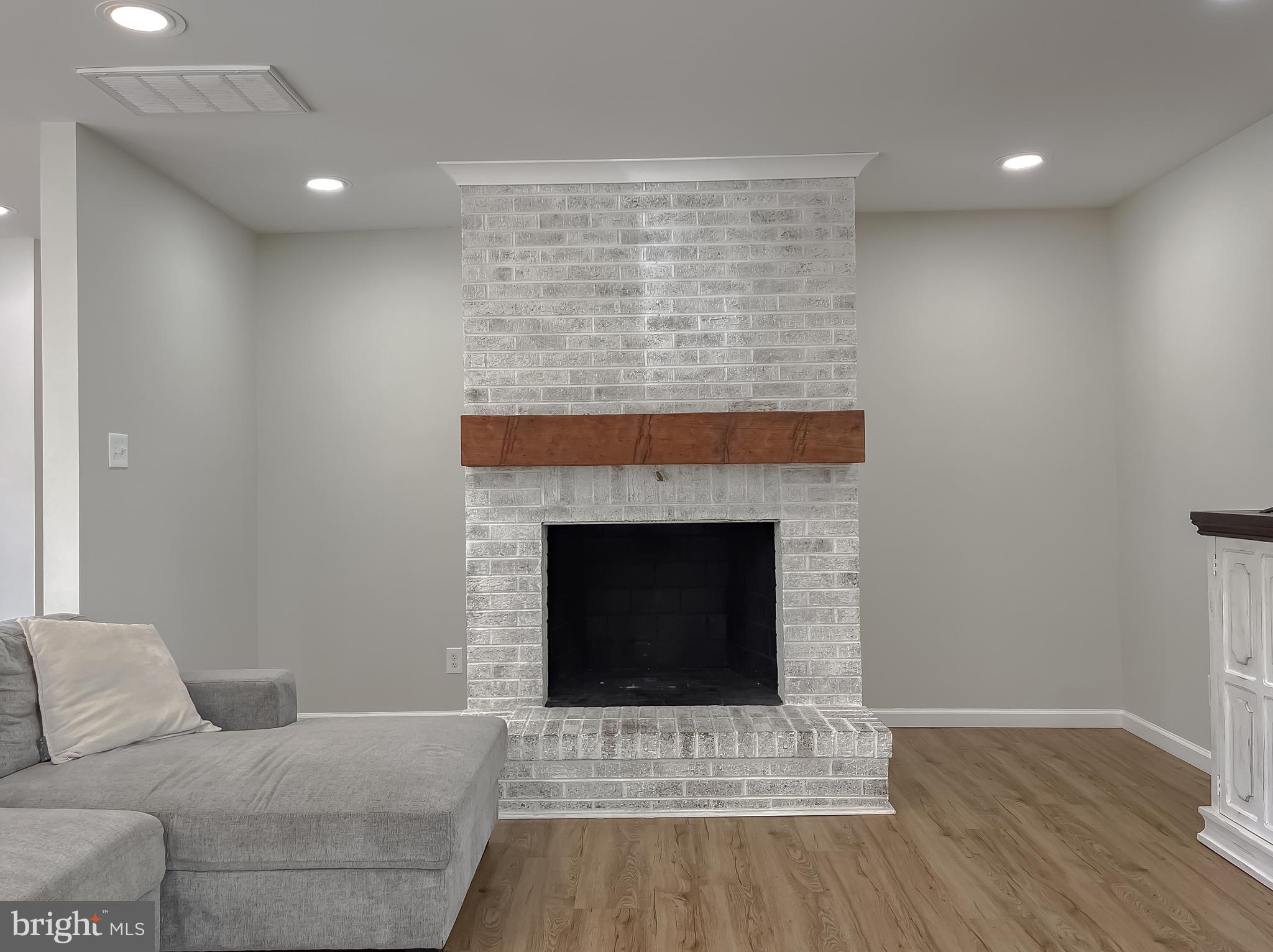 26005 Jones Wharf Road Hollywood, MD 20636 - Photo 16 of 66 a living room with a fireplace and wooden floor