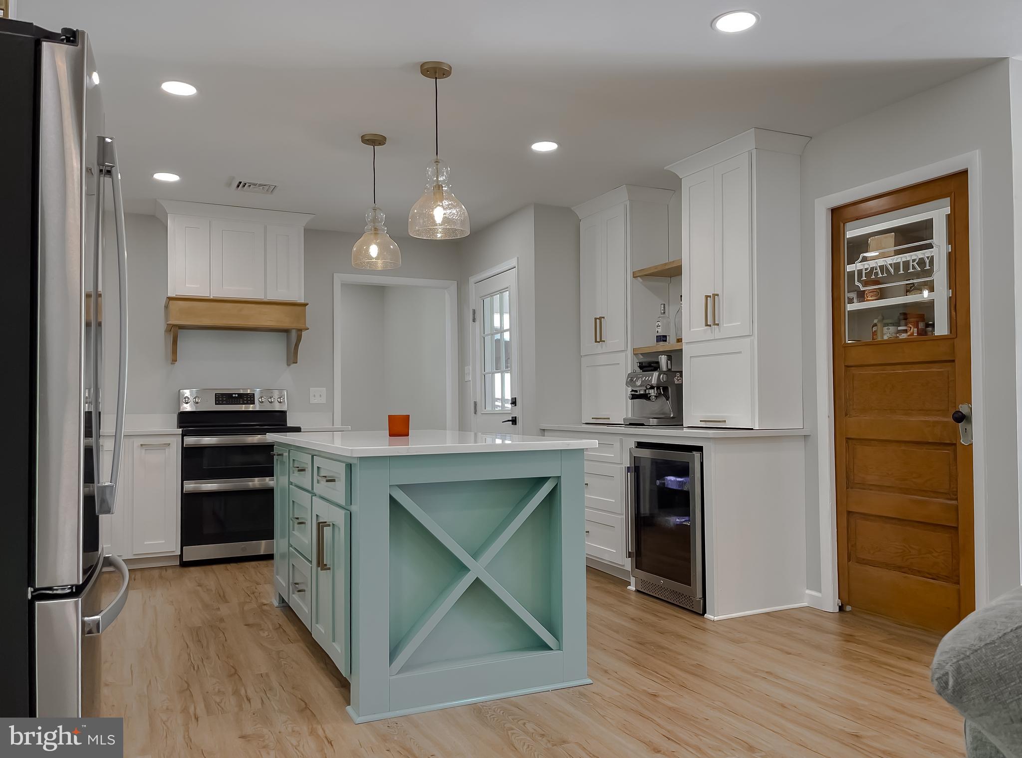 26005 Jones Wharf Road Hollywood, MD 20636 - Photo 21 of 66 a kitchen with kitchen island white cabinets and stainless steel appliances