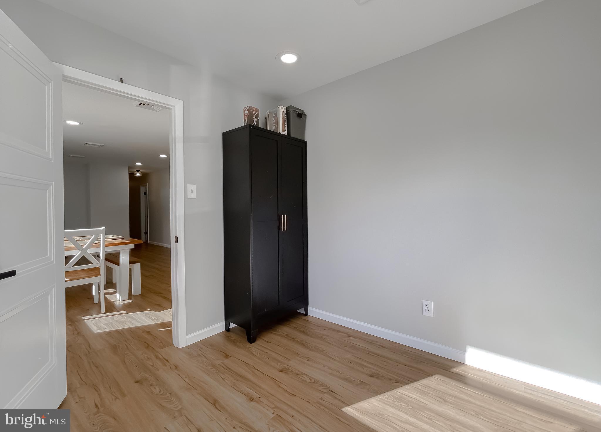 26005 Jones Wharf Road Hollywood, MD 20636 - Photo 40 of 66 an empty room with wooden floor and a bathroom
