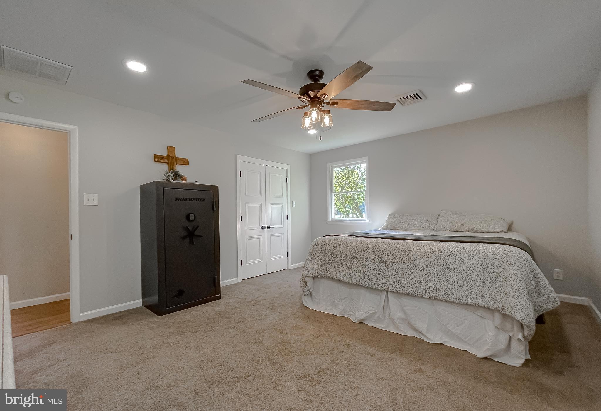 26005 Jones Wharf Road Hollywood, MD 20636 - Photo 49 of 66 a spacious bedroom with a bed and a chandelier