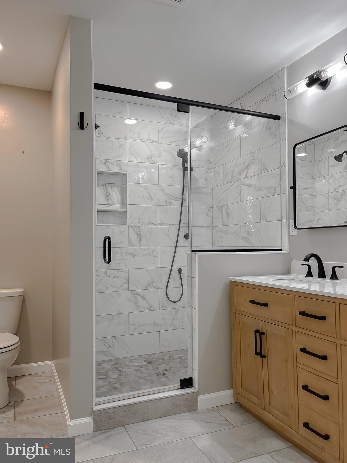 26005 Jones Wharf Road Hollywood, MD 20636 - Photo 51 of 66 a bathroom with a shower sink and mirror