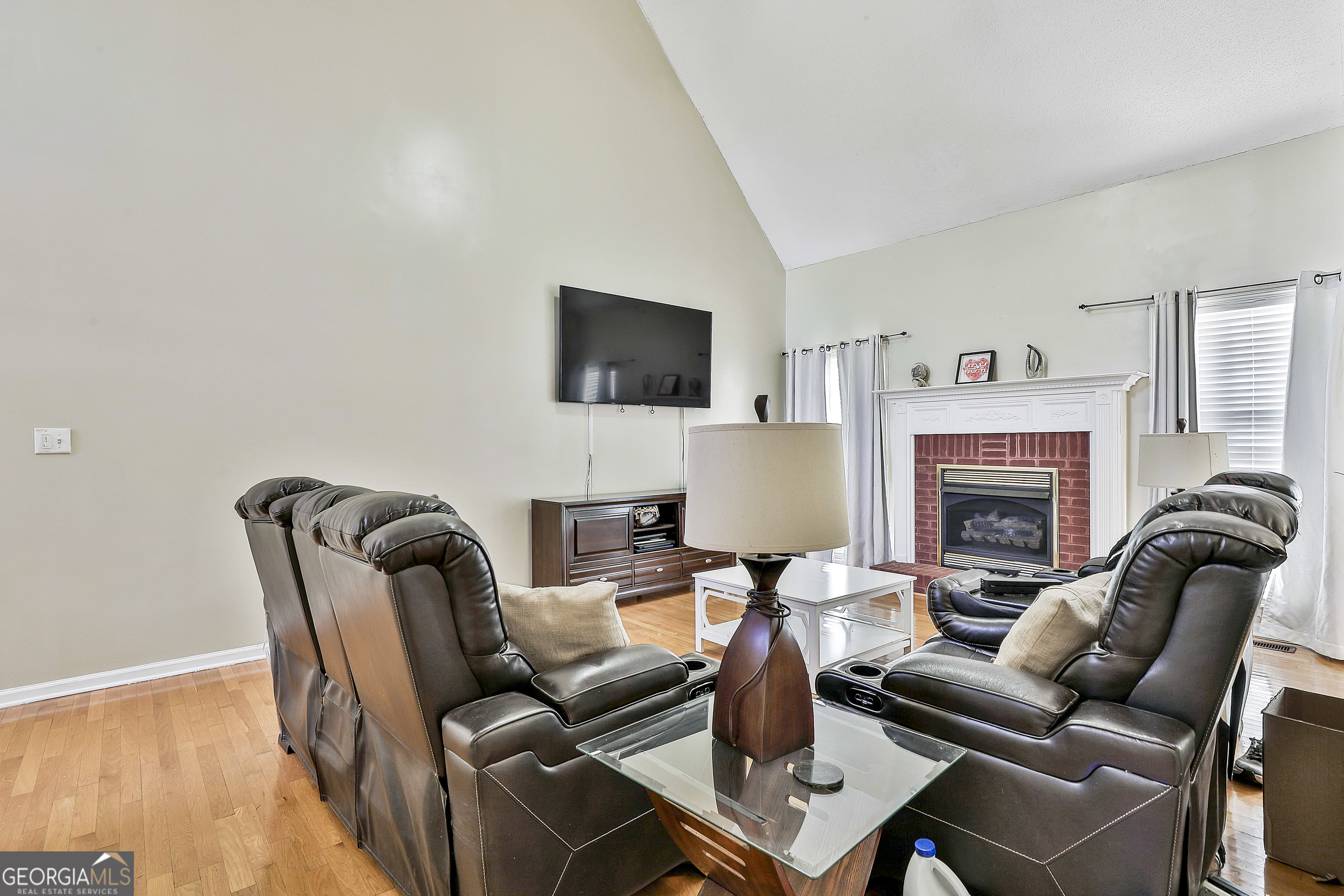 1317 Cheatham Road Griffin, GA 30223 - Photo 21 of 41 a living room with furniture a fireplace and a flat screen tv