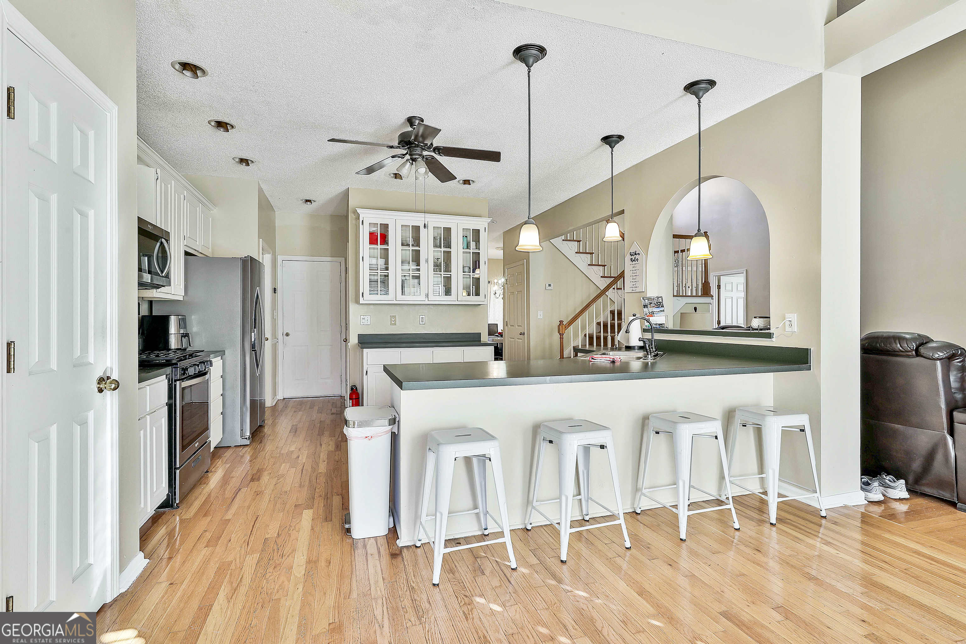 1317 Cheatham Road Griffin, GA 30223 - Photo 26 of 41 a kitchen with stainless steel appliances granite countertop a sink a stove a refrigerator and island with wooden floor