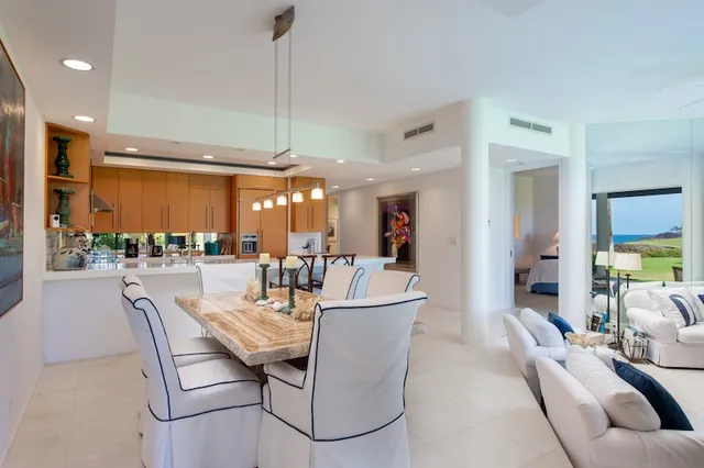a kitchen with stainless steel appliances kitchen island granite countertop a table and chairs