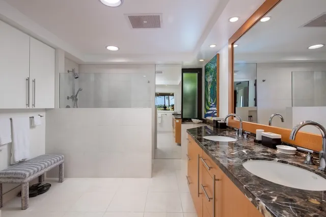 a bedroom with two beds and next to a window