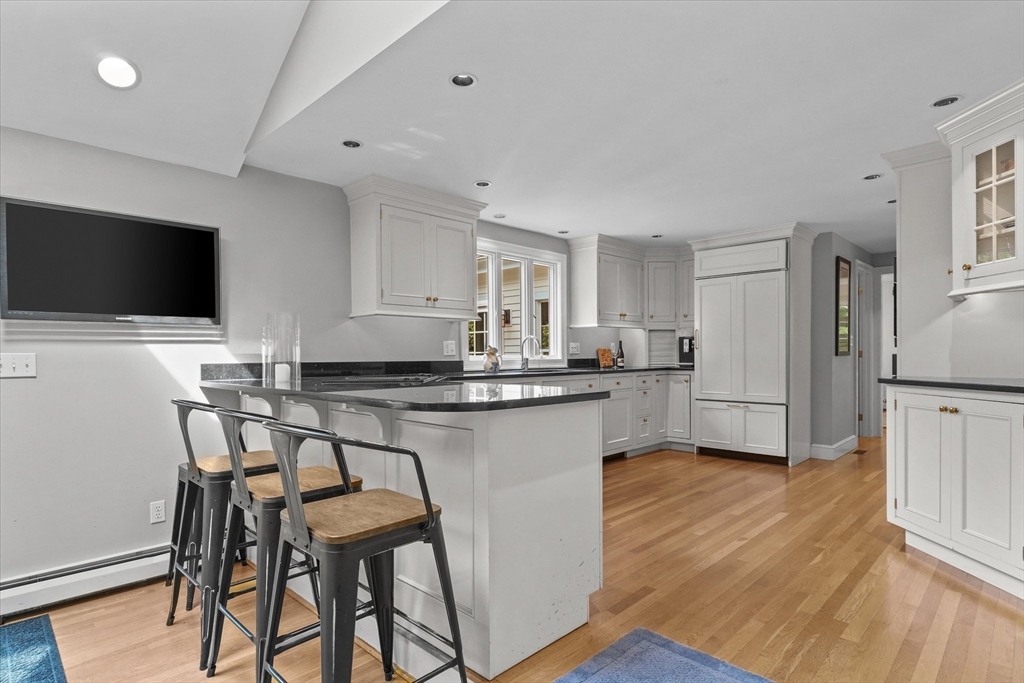 7 Kimball Road Boxford, MA 01921 - Photo 7 of 41 a kitchen with kitchen island a dining table chairs and a refrigerator