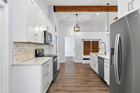 a bedroom with a bed a couch and a flat tv screen on dresser