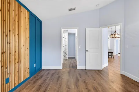 a view of an empty room with wooden floor and windows