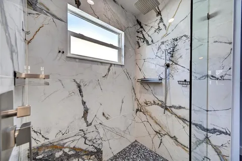 an empty room with wooden floor chandelier fan and windows