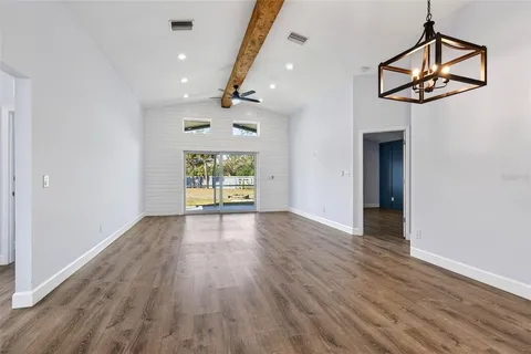 a kitchen with stainless steel appliances a white table chairs and a refrigerator