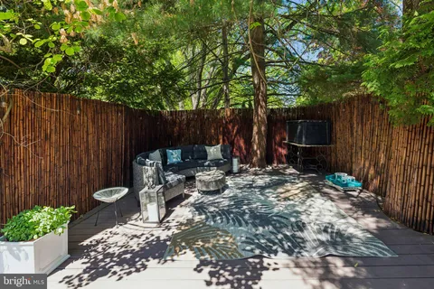 a kitchen with granite countertop lots of wooden cabinets stainless steel appliances a dining table and chairs