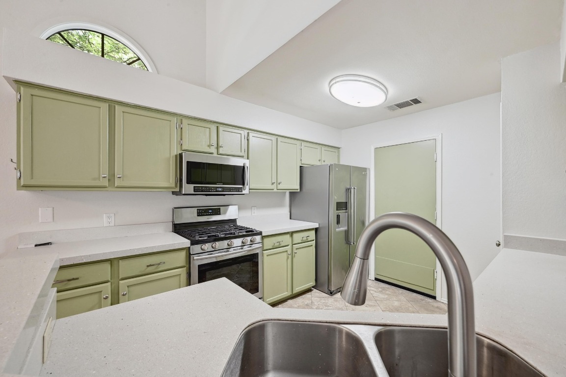 7201 Pine Bluffs Trail Austin, TX 78729 - Photo 12 of 25 a kitchen with a sink stainless steel appliances and cabinets
