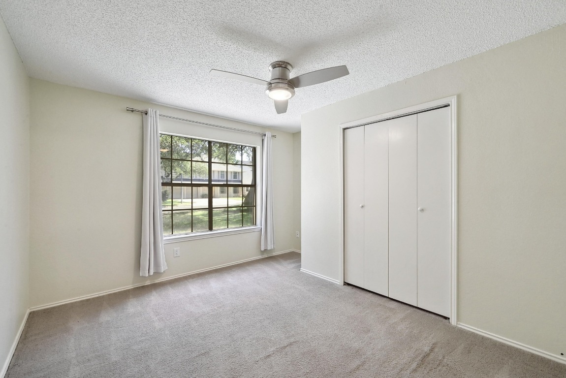 7201 Pine Bluffs Trail Austin, TX 78729 - Photo 13 of 25 an empty room with windows and fan