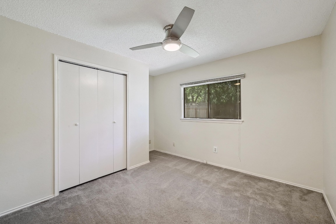 7201 Pine Bluffs Trail Austin, TX 78729 - Photo 16 of 25 an empty room with a ceiling fan and a window