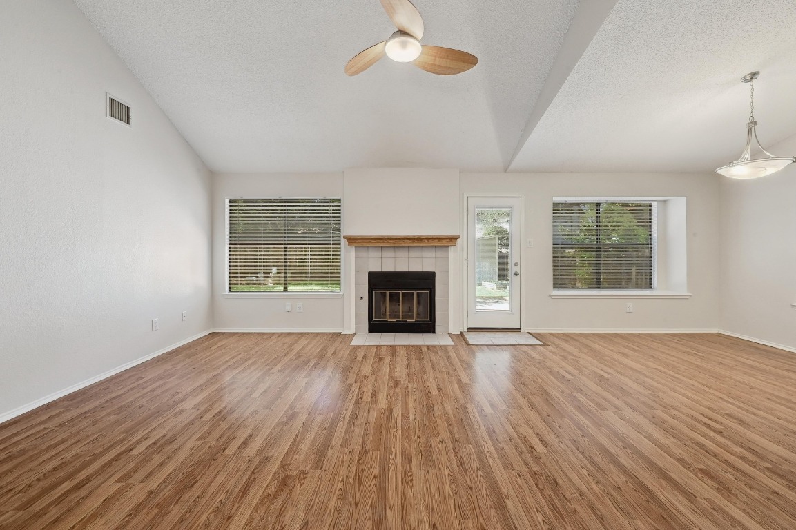7201 Pine Bluffs Trail Austin, TX 78729 - Photo 4 of 25 an empty room with wooden floor fireplace and windows