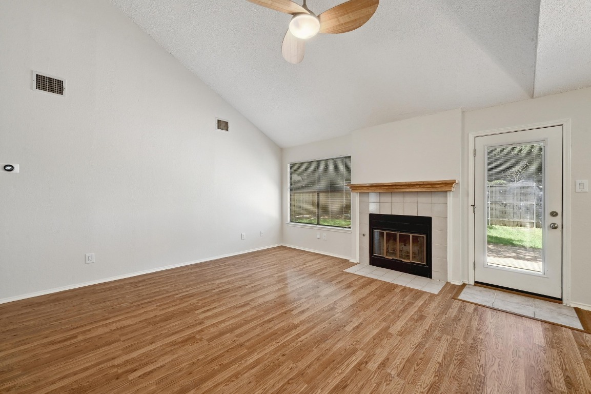 7201 Pine Bluffs Trail Austin, TX 78729 - Photo 5 of 25 a view of an empty room with wooden floor fireplace and a window