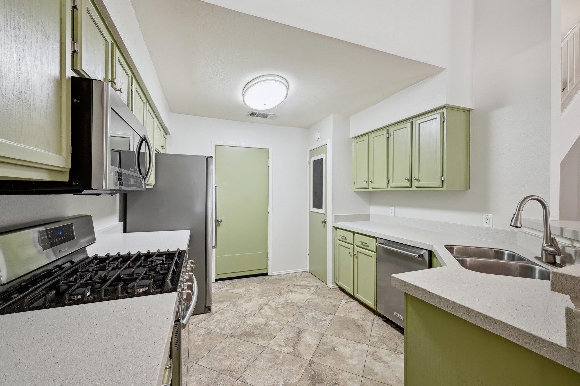 7201 Pine Bluffs Trail Austin, TX 78729 - Photo 9 of 25 a kitchen with a sink stove and refrigerator