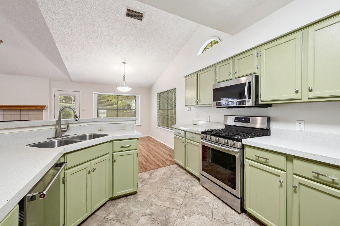 7201 Pine Bluffs Trail Austin, TX 78729 - Photo 10 of 25 a kitchen with a sink stove and microwave