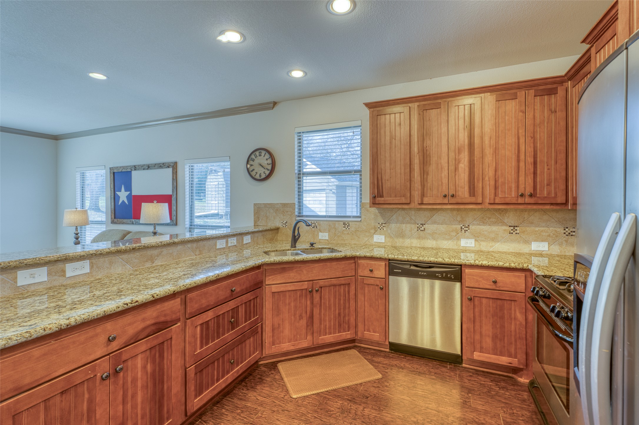489 Nordic Ridge Road Bertram, TX 78605 - Photo 6 of 19 Kitchen with wood finish cabinetry, stainless steel appliances, light stone countertops, healthy amount of natural light, and recessed lighting