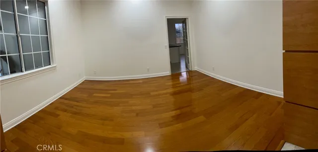 a view of an empty room with wooden floor