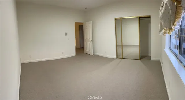 an empty room with closet and windows