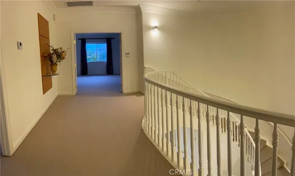 a view of a hallway with wooden floor and staircase