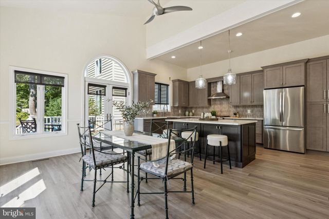 a kitchen with kitchen island granite countertop a sink cabinets and stainless steel appliances