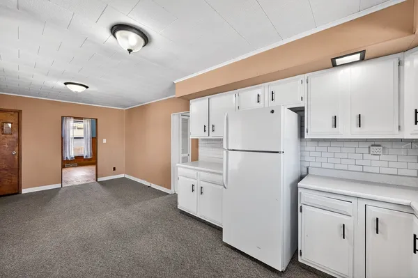 an empty room with wooden floor chandelier fan and windows