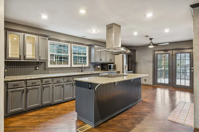 a large kitchen with stainless steel appliances granite countertop a stove and a sink