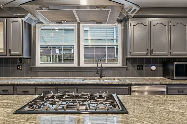 a kitchen with granite countertop a stove and a microwave
