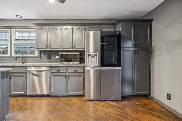 a kitchen with stainless steel appliances granite countertop a refrigerator and a sink