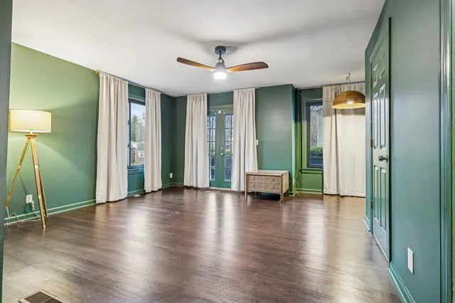 an empty room with wooden floor and a bathroom