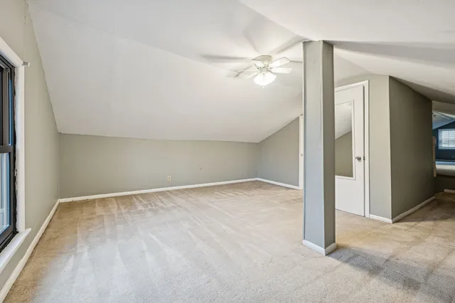an empty room with closet and a chandelier fan