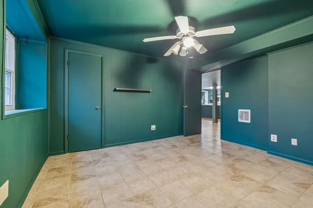 a view of a livingroom with a chandelier fan and a window