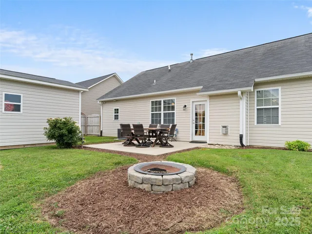 a view of a backyard with table and chairs and potted plants